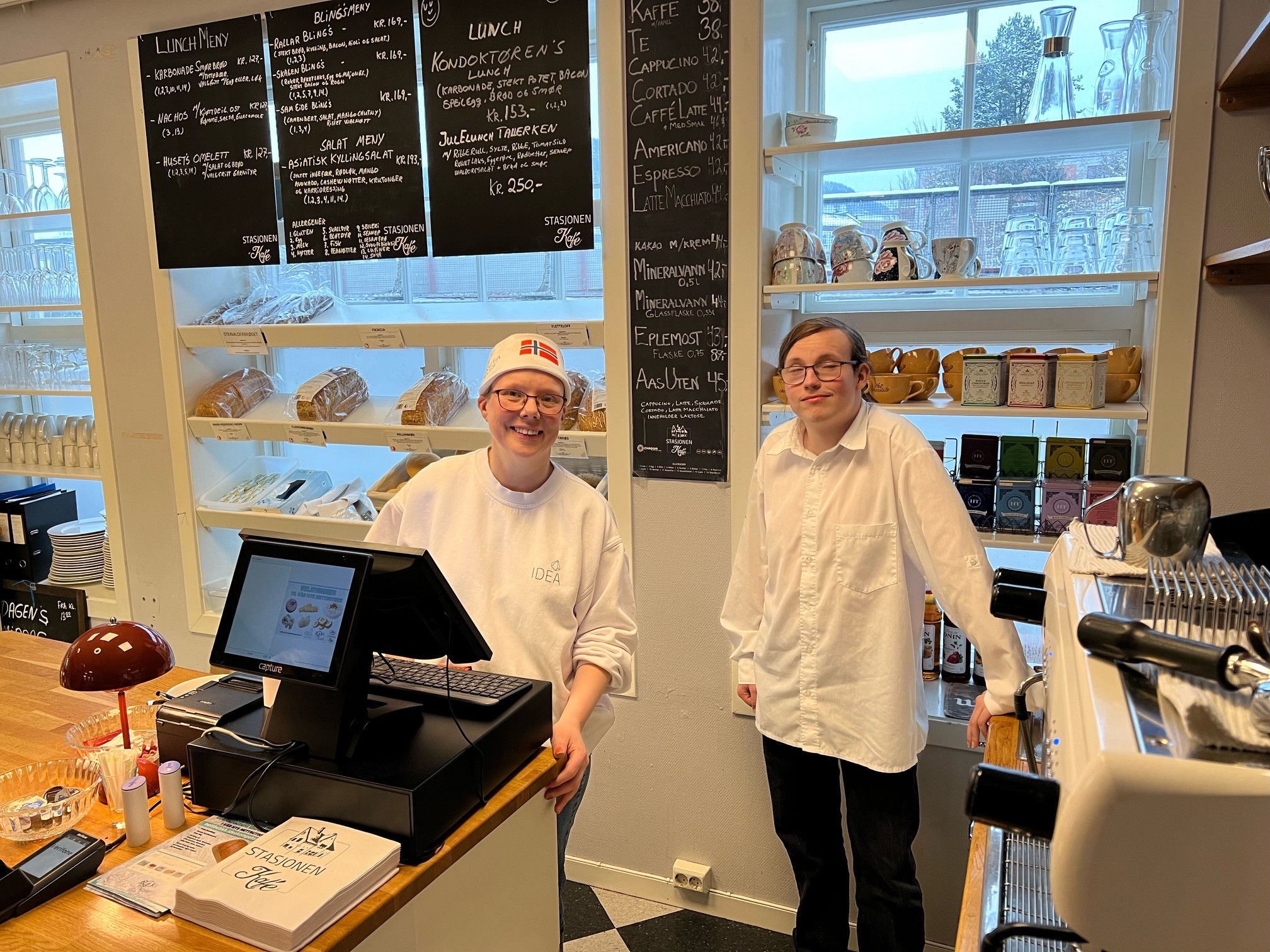 Aase og Kristian bak kassa på kafeen som driftes av IDEA på Notodden. Kristian er lærekandidat.